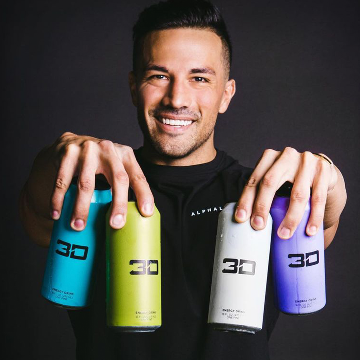 Christian smiling and holding a variety of 3D energy drinks by displaying them in front of him.