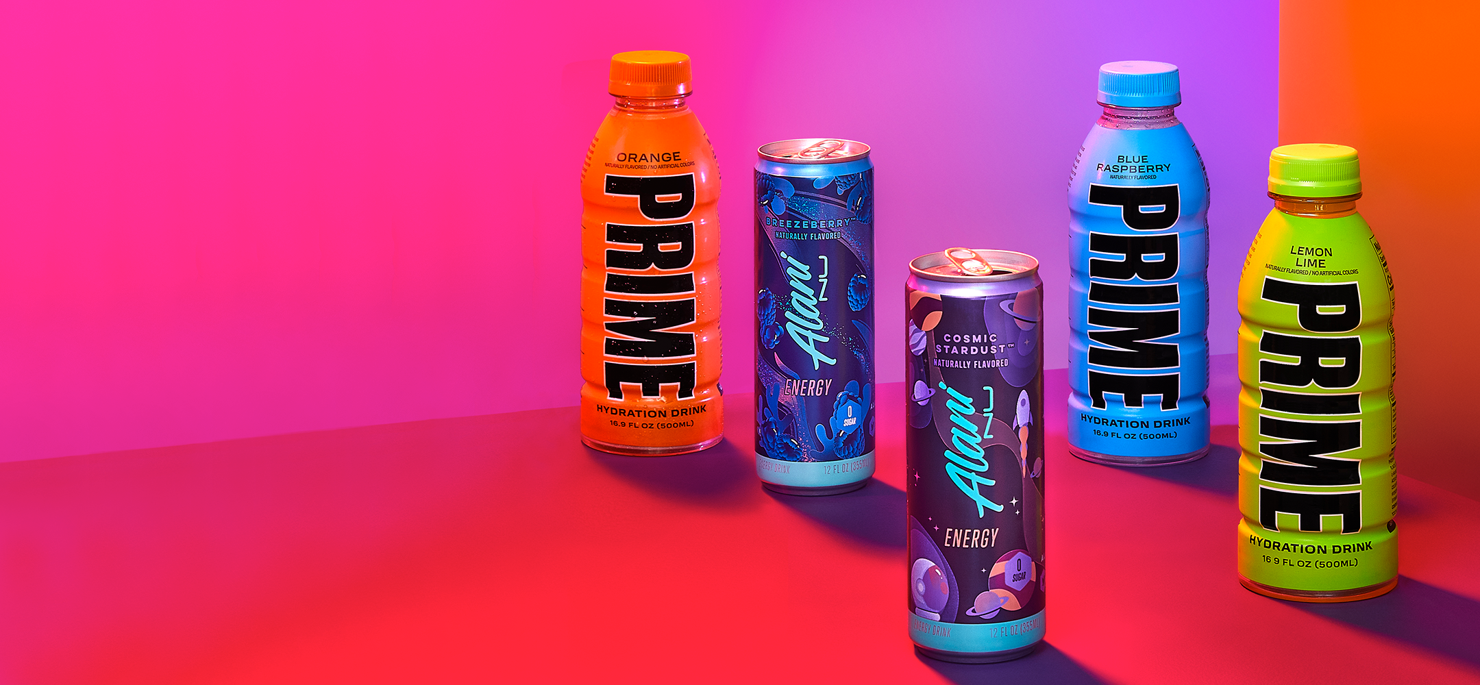  An eye-catching array of Prime hydration drinks in Blue Raspberry and Lemon Lime, alongside Alani Nu energy drinks in Cosmic Stardust flavor, is elegantly displayed.