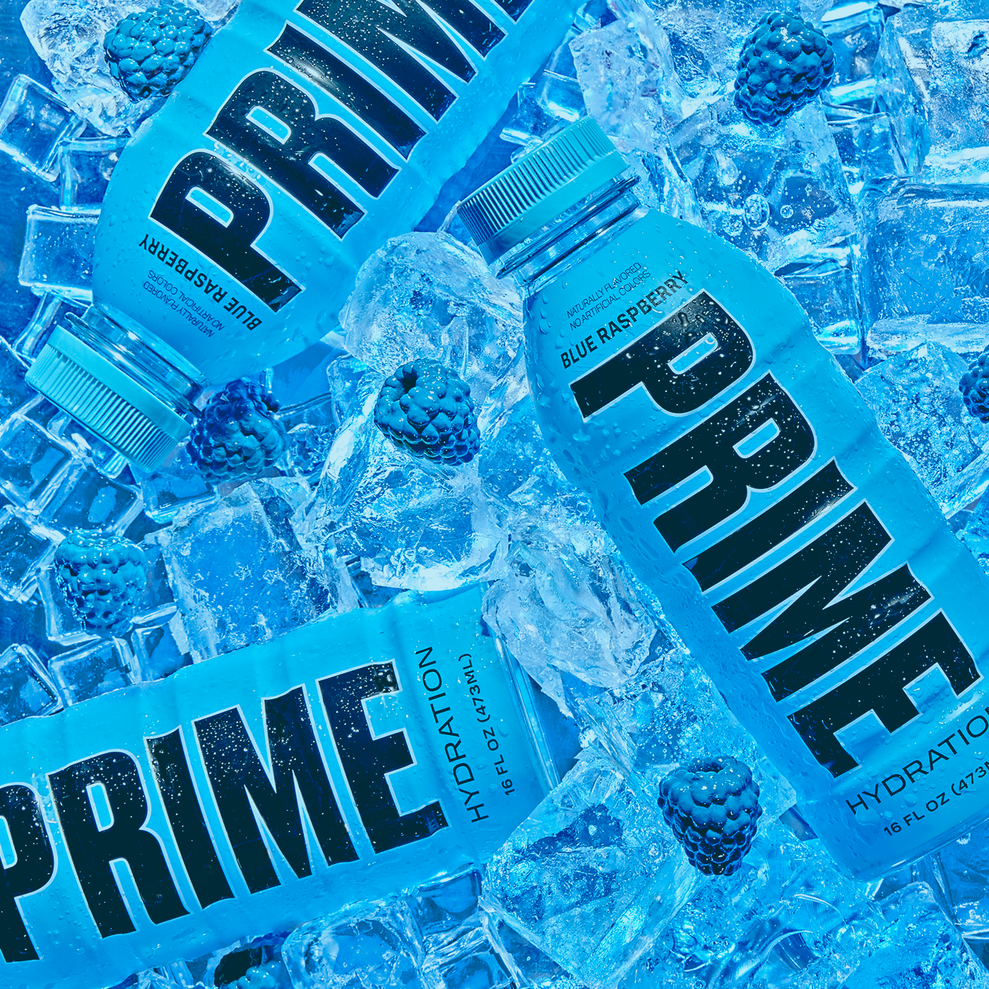 Several bottles of 'PRIME' hydration drink in blue raspberry flavor, submerged in ice, with blackberries scattered throughout, all cast in a monochromatic blue tone.